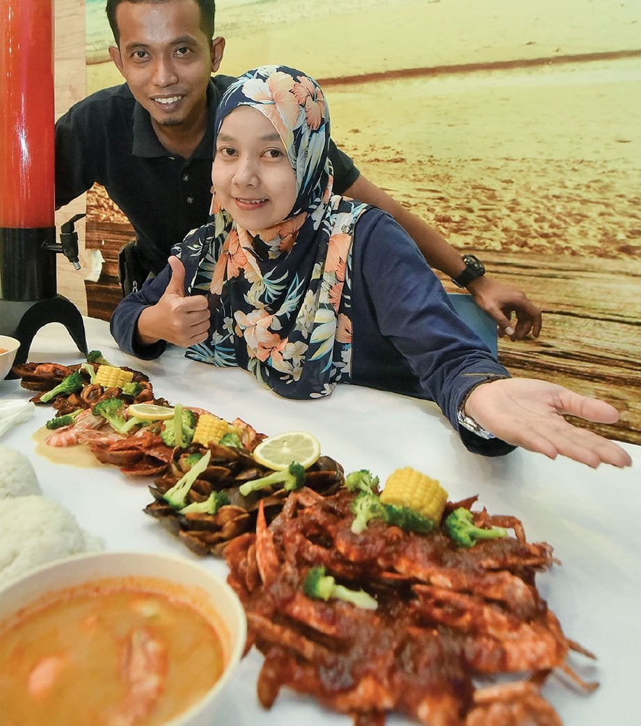Mohd Azlan dan Murniyati bersama lambakan makanan laut yang menerbitkan suasana meriah.