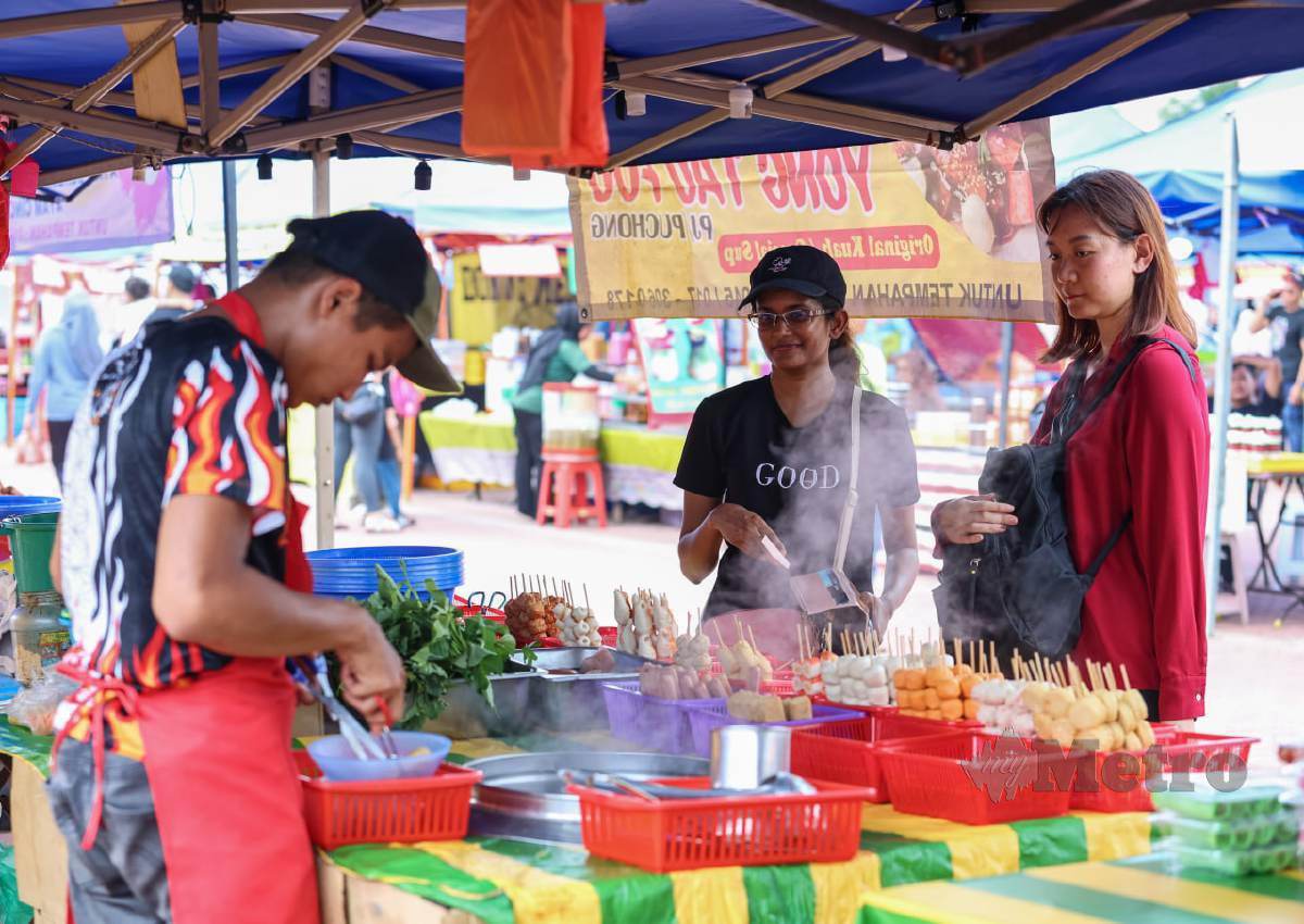 ELKE (kiri) bersama Meiyin mengambil peluang mengunjung bazar membeli makanan pada tinjauan orang bukan Muslim yang turut membeli makanan di Bazar Ramadan Seksyen 13, Shah Alam. FOTO Aswadi Alias