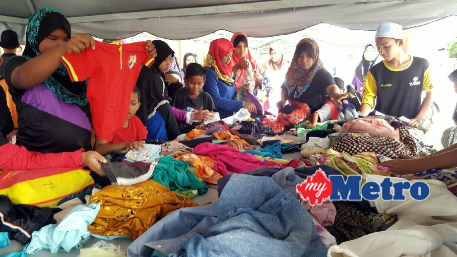 Orang ramai memilih pakaian pada Pasar Percuma di pekarangan Masjid Al-Ehsan Kampung Temonyong, hari ini. FOTO Hamzah Osman