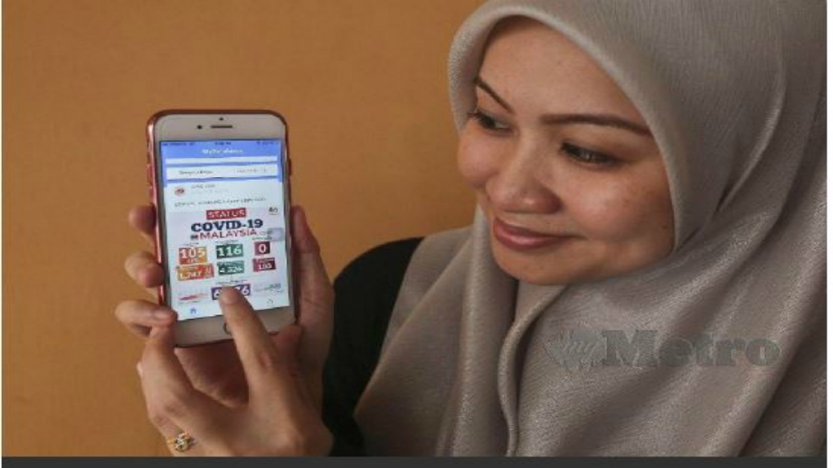 JALINA Radiha Jafri melayari aplikasi MySejahtera di telefon pintarnya untuk mendapatkan maklumat mengenai Covid-19. FOTO Ghazali Kori.  