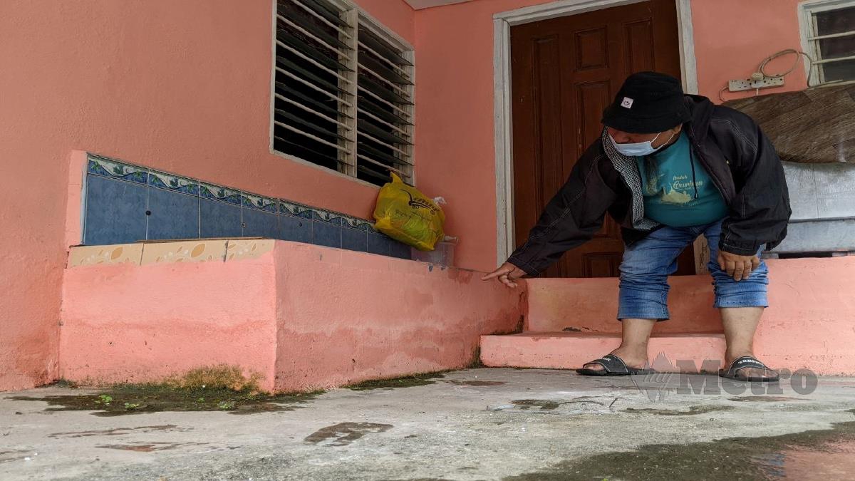GHAZALI menunjukkan kesan paras air pada dinding rumahnya yang rosak akibat sering ditenggelami banjir sejak tiga tahun lalu. FOTO ZUHAINY ZULKIFFLI