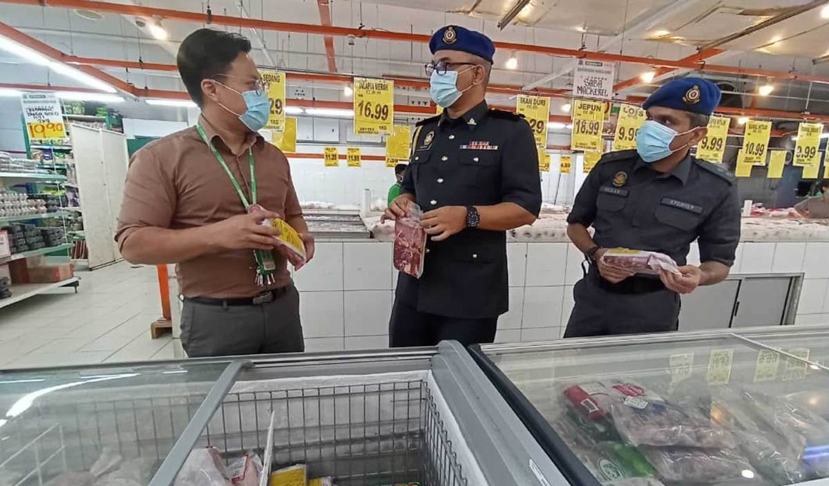 KETUA Penguatkuasa KPDNHEP Kuala Pilah, Ahmad Khuzairi (tengah) ketika melakukan pemeriksaan daging sejuk beku di sebuah pasar raya Kuala Pilah. FOTO Ihsan KPDNHEP