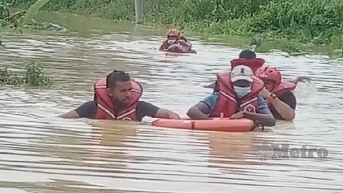 ANGGOTA bomba menyelamatkan lima individu termasuk seorang kanak-kanak dan wanita yang terperangkap dalam banjir di Jambatan Kuala Kali, hari ini.  FOTO Ihsan Bomba.