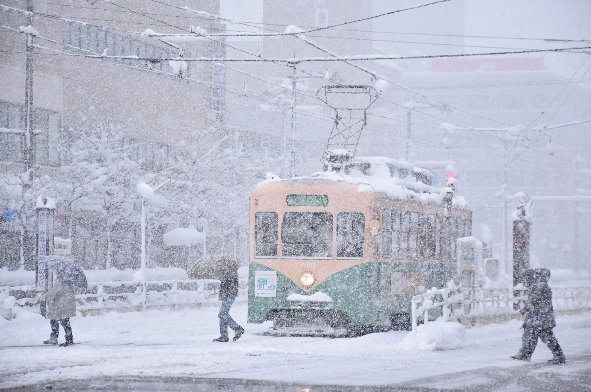 ORANG ramai menyeberangi jalan di bandar Toyama, dalam keadaan salji tebal. FOTO Jiji Press / AFP / Japan Out