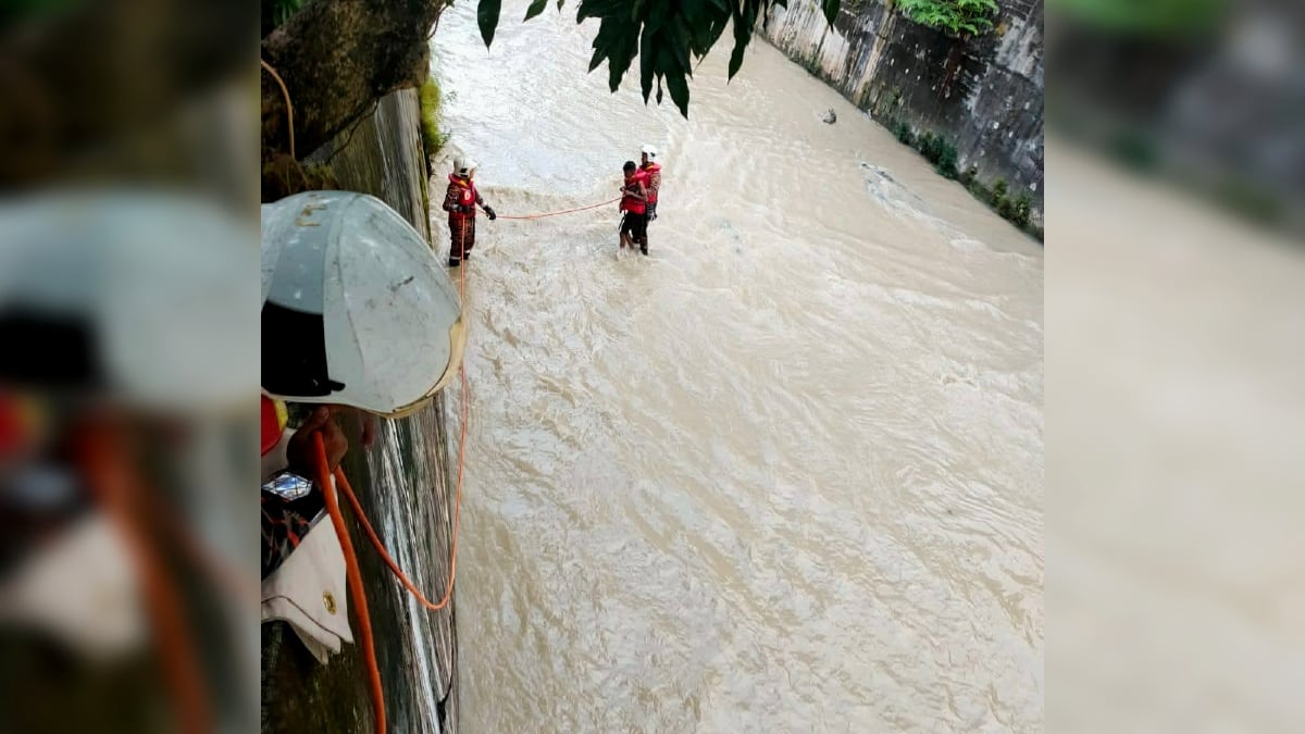 ANGGOTA bomba menyelamatkan dua remaja yang terperangkan ketika memancing di Sungai Kerayong di Taman Pandan Mewah, hari ini. FOTO Ihsan JBPM.