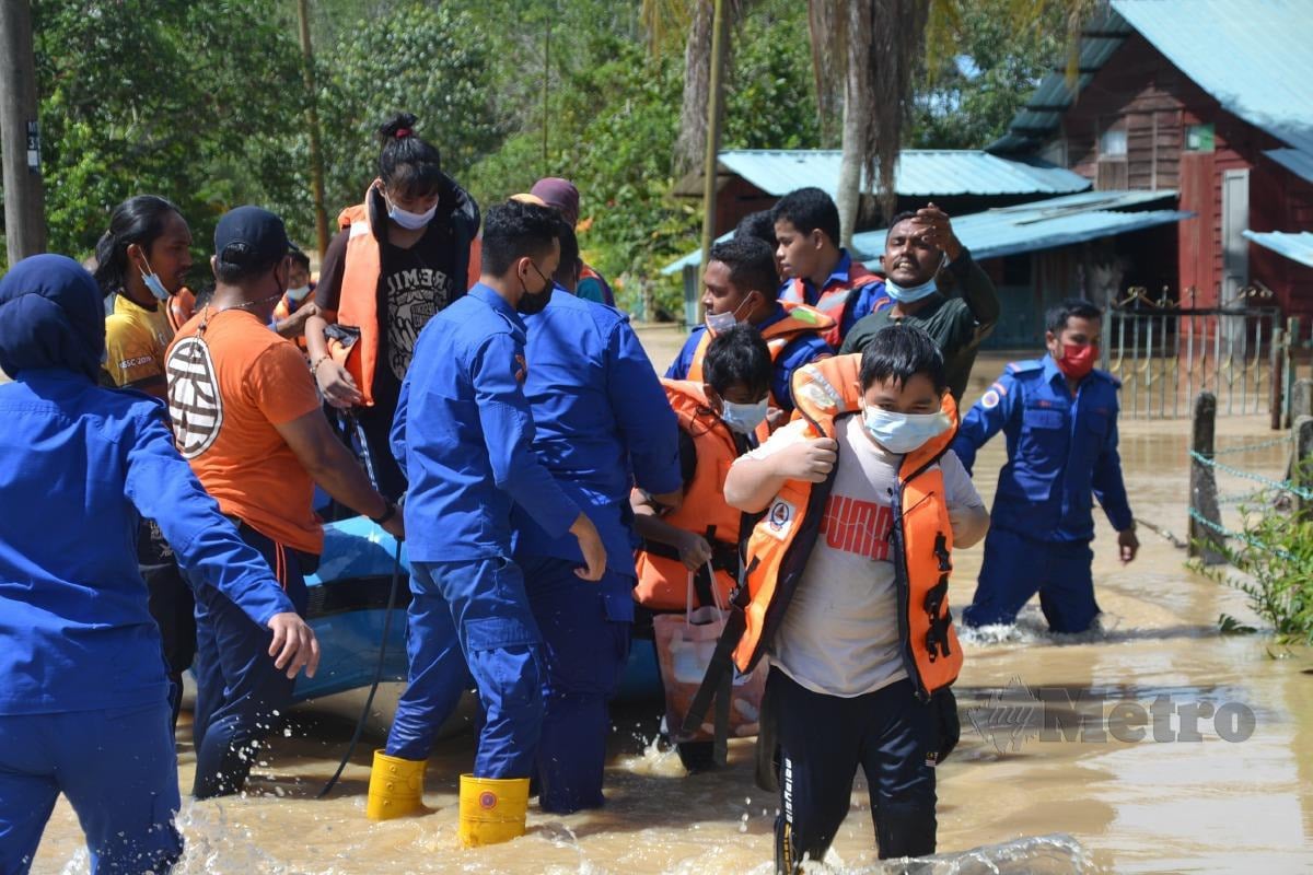  Anggota APM menyelamatkan lapan sekeluarga yang terperangkap enam jam di kediaman mereka akibat banjir di Kampung Telok Berembang, Lubok Cina, Masjid Tanah. Foto HASSAN OMAR