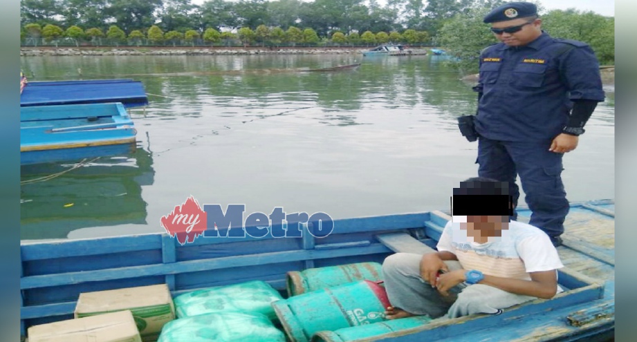 REMAJA lelaki yang ditahan kerana cuba menyeludup keluar barang kawalan di perairan Titingan, Tawau, semalam. FOTO Ihsan APMM