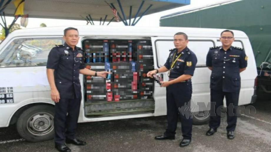 SUPERINTENDAN Rosdi Inai (tengah) bersama pegawai Batalion 11 PGA Kuching menunjukkan bir yang dirampas. FOTO MELVIN JONI
