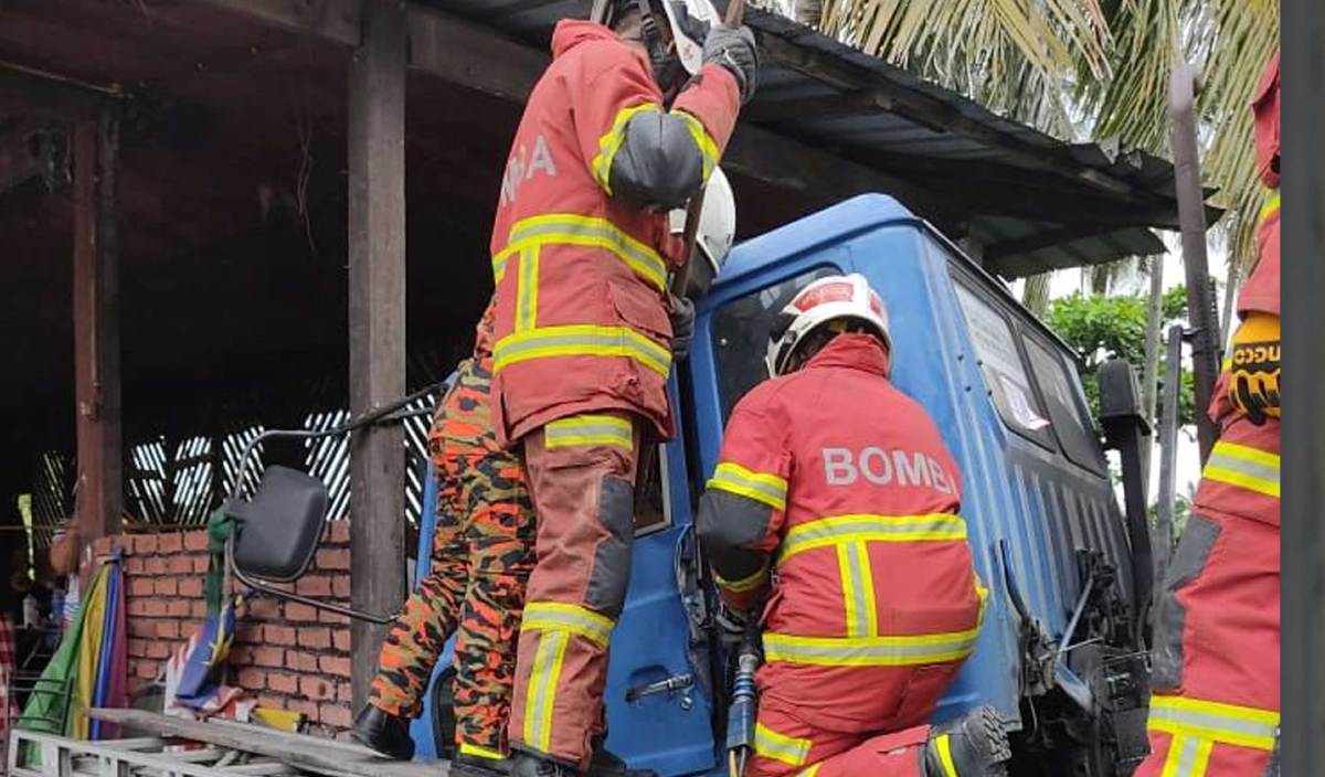 ANGGOTA bomba membawa keluar mayat pemandu treler yang tersepit selepas treler dipandunya terbabas ke dalam parit dan melanggar tembok sebuah bengkel kereta di Jalan Kapar Batu 15. FOTO Ihsan JBPM
