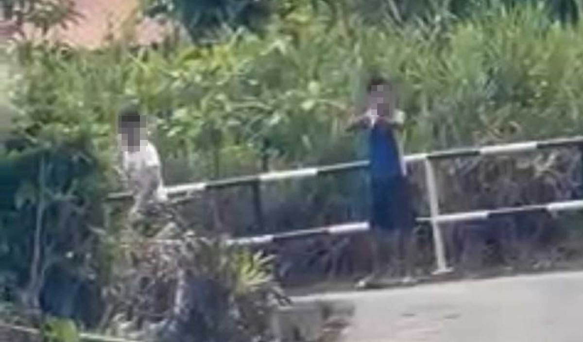 TANGKAP layar daripada rakaman sebuah video yang tular menunjukkan dua lelaki mengacukan senjata ke arah seorang individu di Tabuan Dayak.
