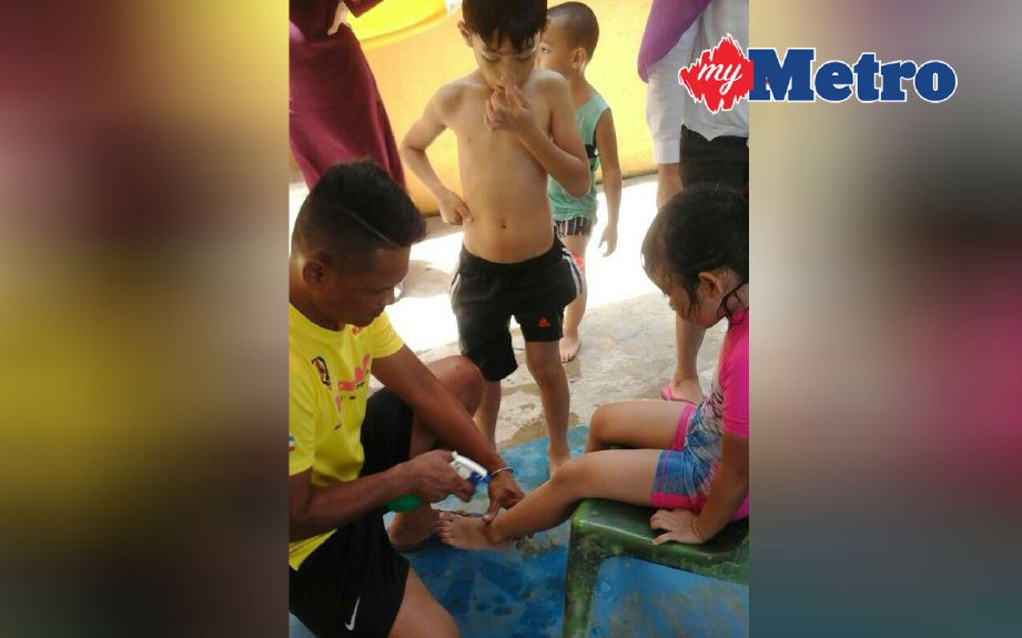 KANAK-kanak yang disengat obor-obor diberi rawatan awal oleh anggota APM di kawasan menara penyelamat pantai Tanjung Aru 2, Kota Kinabalu. FOTO ihsan APM