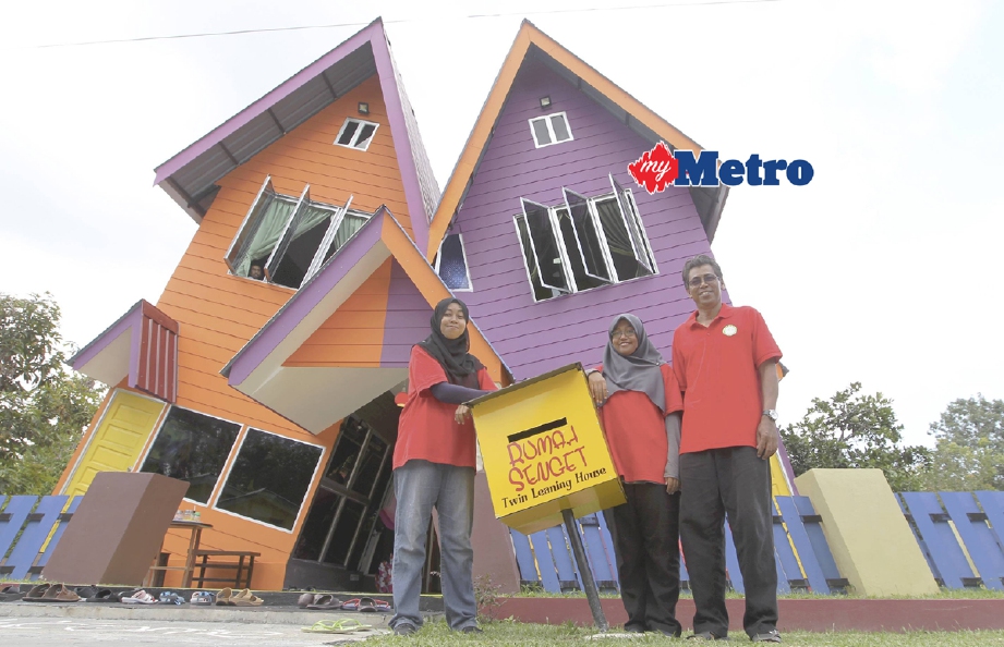 Pemilik MNM Home Whimsical Houses, Profesor Dr Mahamad Tayib (kanan) bersama anaknya di depan rumah senget MNM Home Whimsical House di Kampung Changkat Setol, Changlun, Kedah. - Foto SHARUL HAFIZ ZAM 