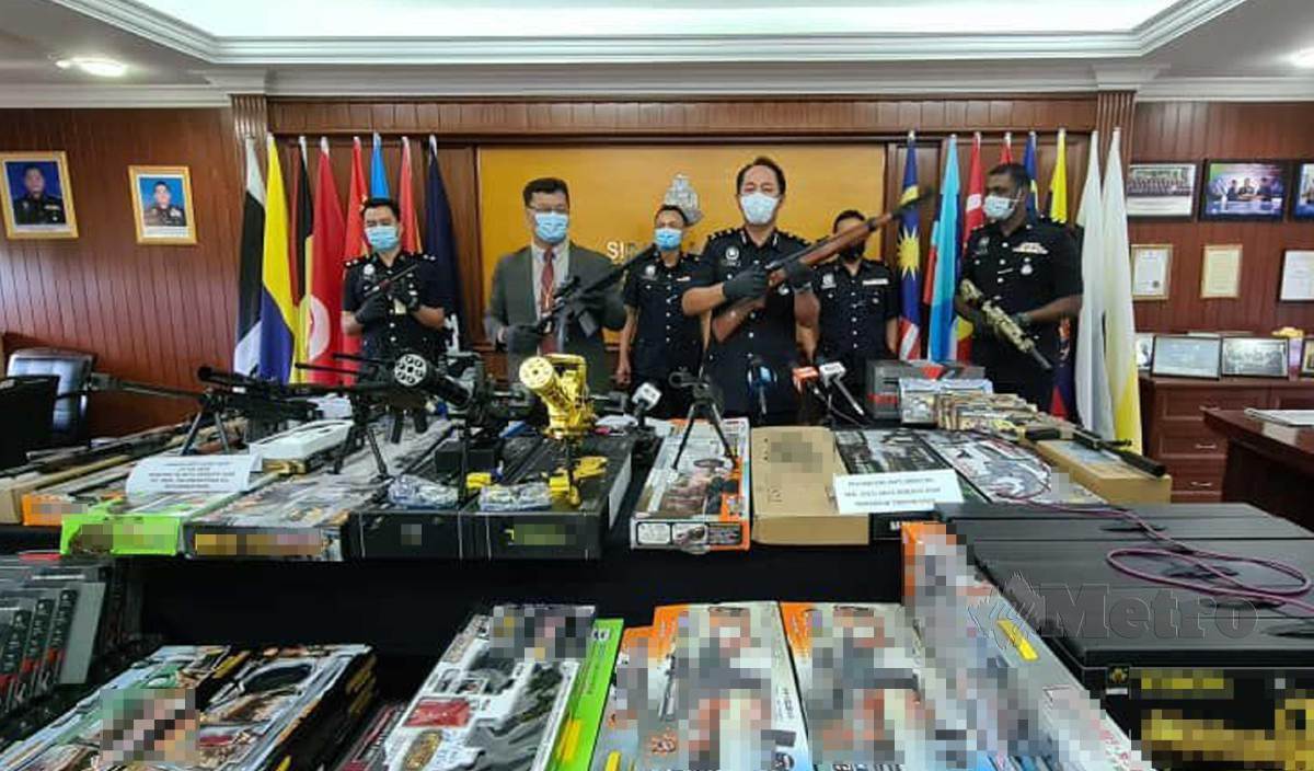 JAUTEH Dikun (tiga kanan) menunjukkan senjata api permainan dirampas dalam dua serbuan berasingan di Kota Kinabalu dan Penampang. FOTO Juwan Riduan