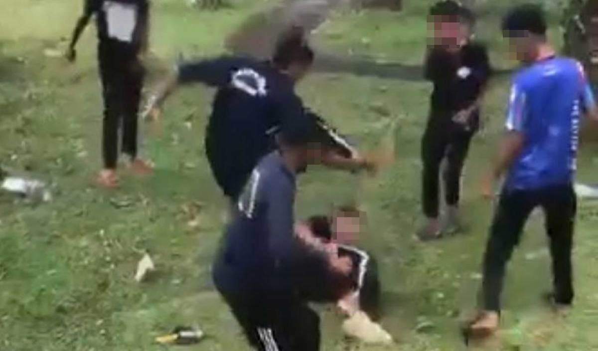 TANGKAP layar video tular memaparkan kejadian seorang remaja lelaki dipukul beberapa remaja lelaki lain di tempat awam. FOTO Tular