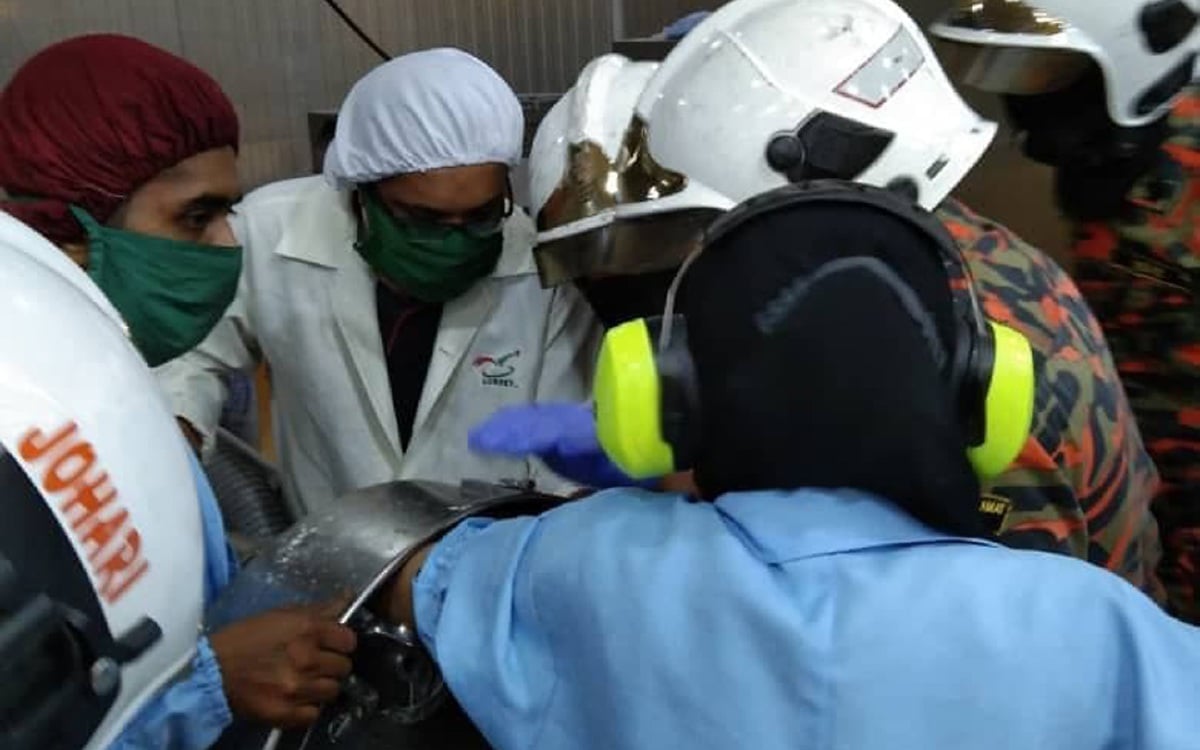 Pekerja kilang ayam menahan kesakitan 15 minit selepas jari kirinya tersepit dalam mesin pengisar di kilang berkenaan di Pelabuhan Lumut, Sitiawan. FOTO IHSAN BOMBA.