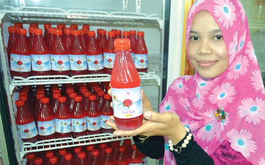 NOR Idawati melekatkan label pada produk minuman segera Sarbat Soul keluaran syarikatnya.