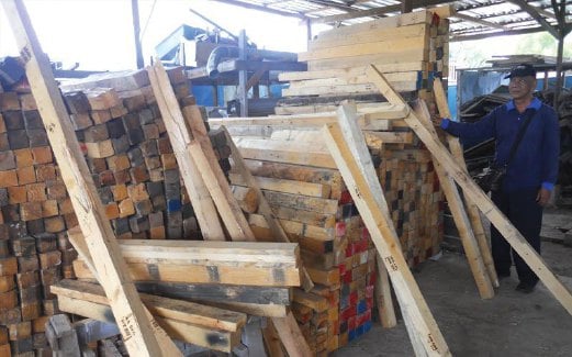 MOHD Fadli menunjukkan longokan kayu pain terpakai untuk dihasilkan perabot di kilangnya di Beranang.