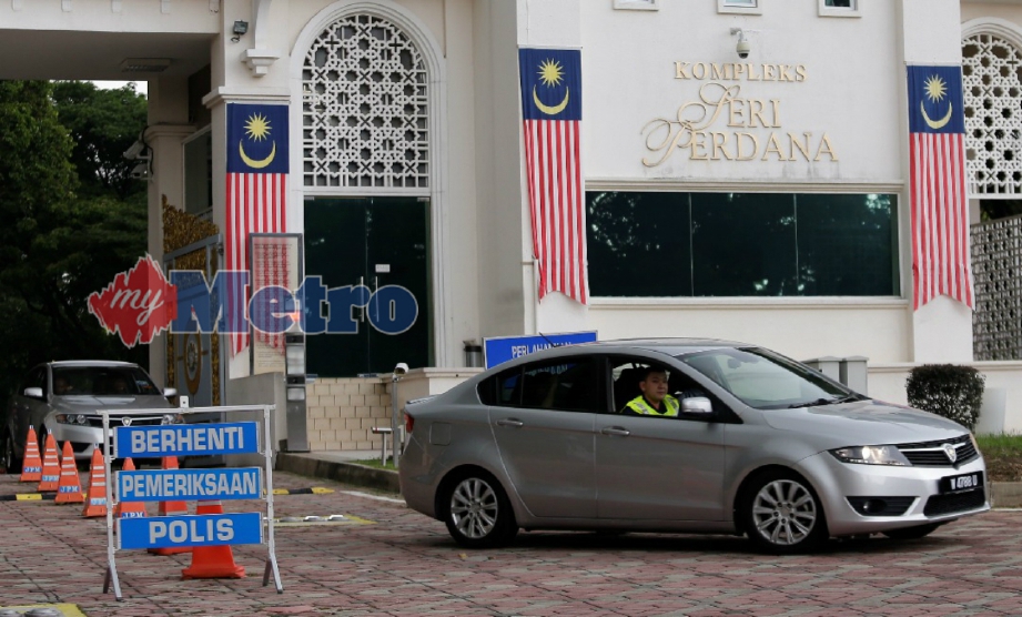 KENDERAAN polis keluar dari Kompleks Seri Perdana, Putrajaya. FOTO Aizuddin Saad