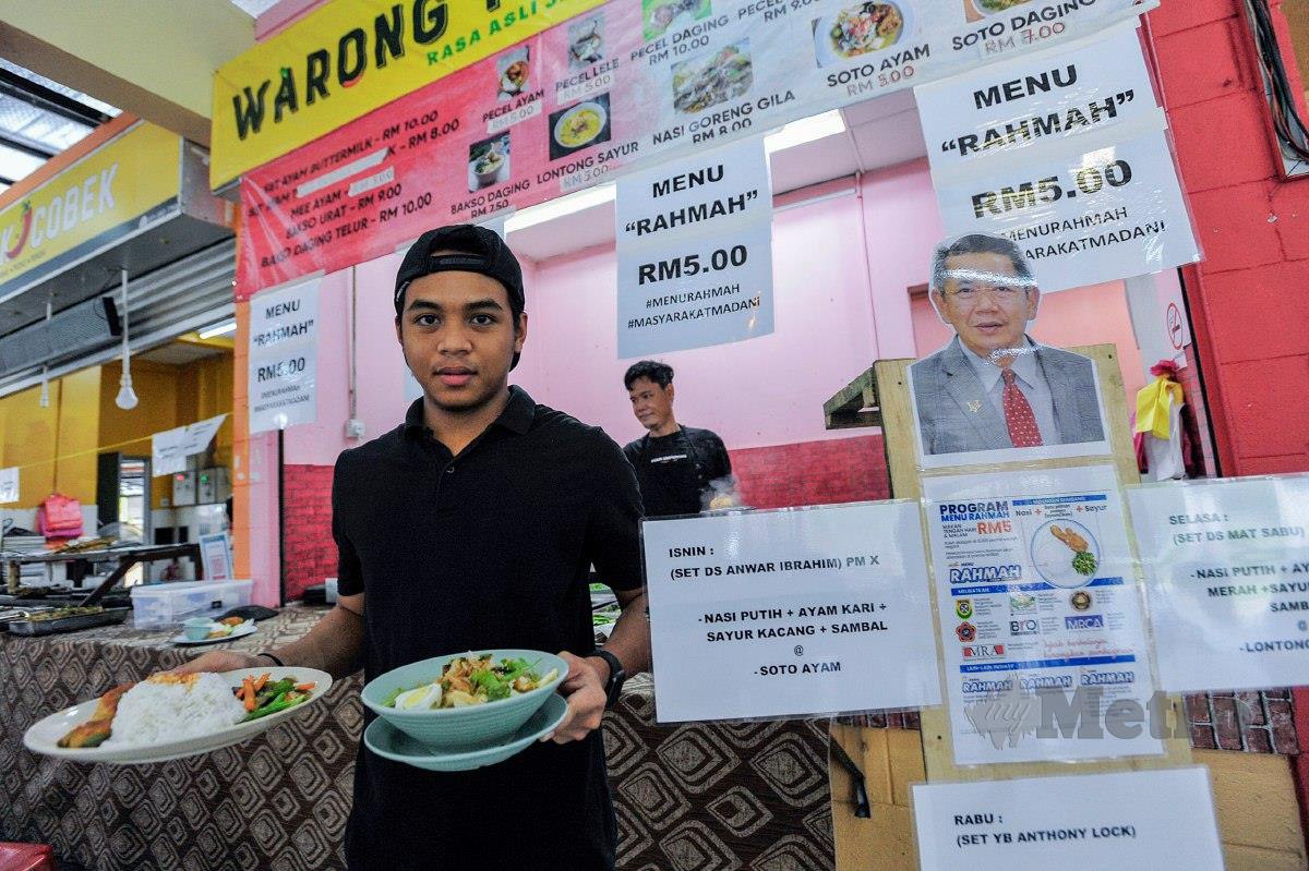 PEKERJA Warong Pecel Lele menunjukkan hidangan Menu Rahmah yang berharga RM5 dan diberi nama menteri bagi setiap menu mengikut hari. FOTO Aizuddin Saad