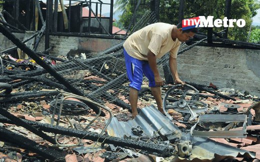 MOHD Amin mencari barangan yang mungkin boleh digunakan selepas rumah sewanya  terbakar.
