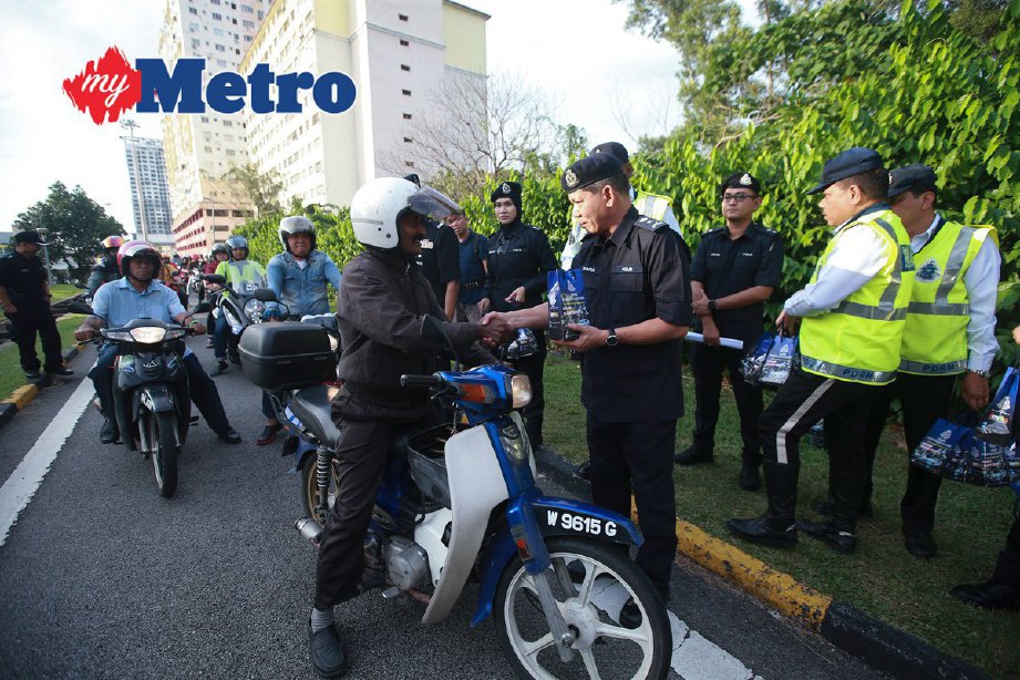 Sharul Othman beramah mesra dengan penunggang motosikal sempena Ops Selamat 11 di Plaza Tol Sungai Besi. FOTOSAIRIEN NAFIS