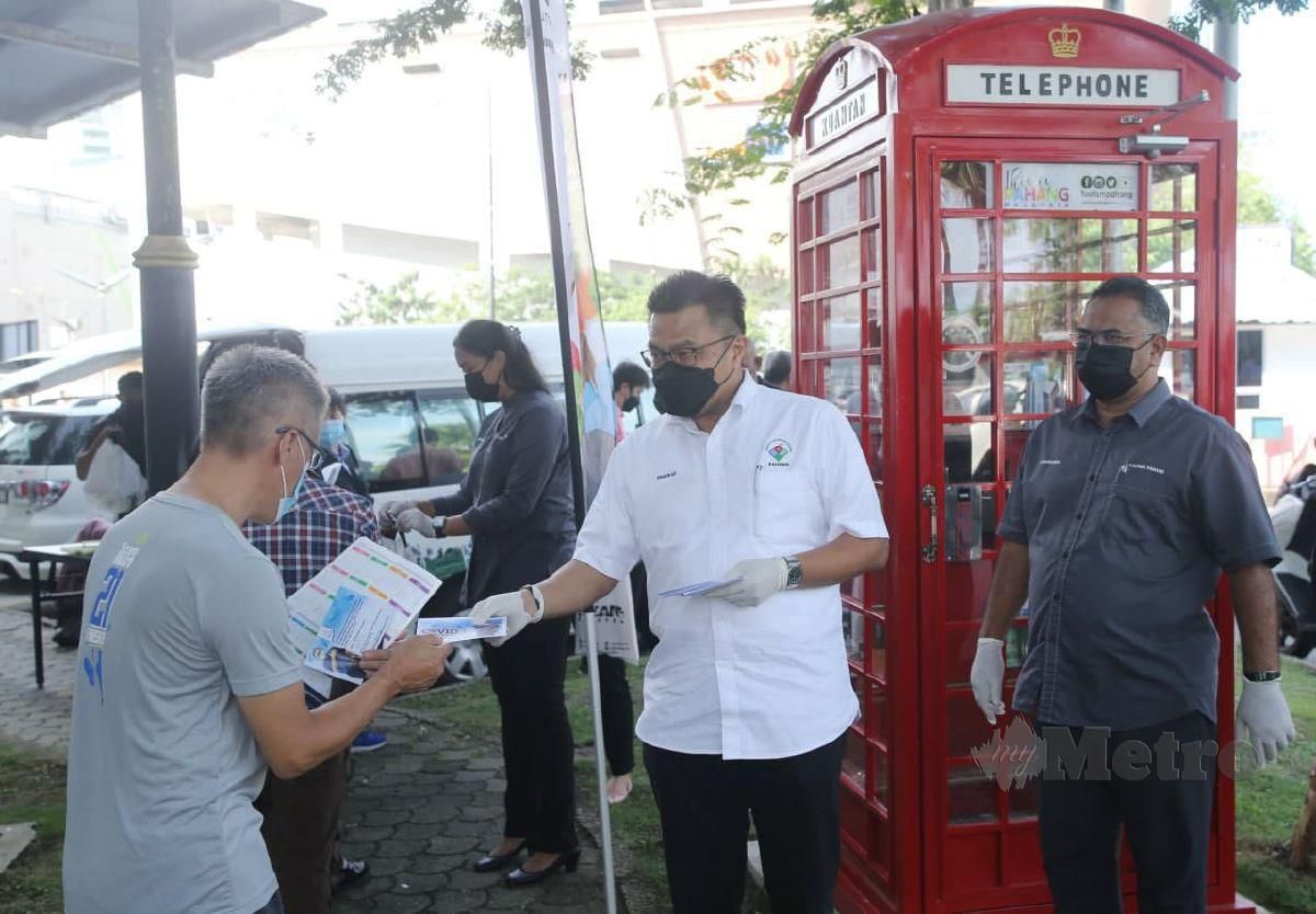 Mohd Sharkar menyerahkan bantuan kepada operator perlancongan negeri Pahang. FOTO FARIZUL HAFIZ AWANG