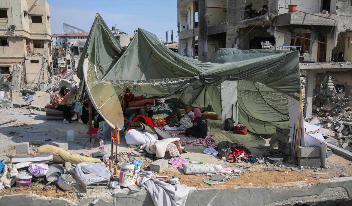 PENDUDUK Palestin berteduh di dalam khemah sementara yang diperbuat daripada payung terjun yang digunakan untuk menghantar bantuan makanan, didirikan di atas runtuhan rumah yang musnah di sekitar hospital Al-Shifa di Gaza. FOTO AFP