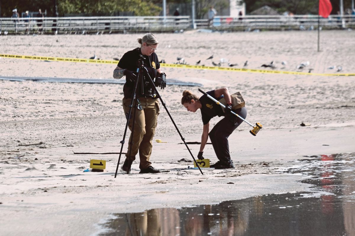 POLIS melakukan siasatan di kawasan pantai yang menjadi lokasi penemuan mayat tiga beranak itu. FOTO AFP
