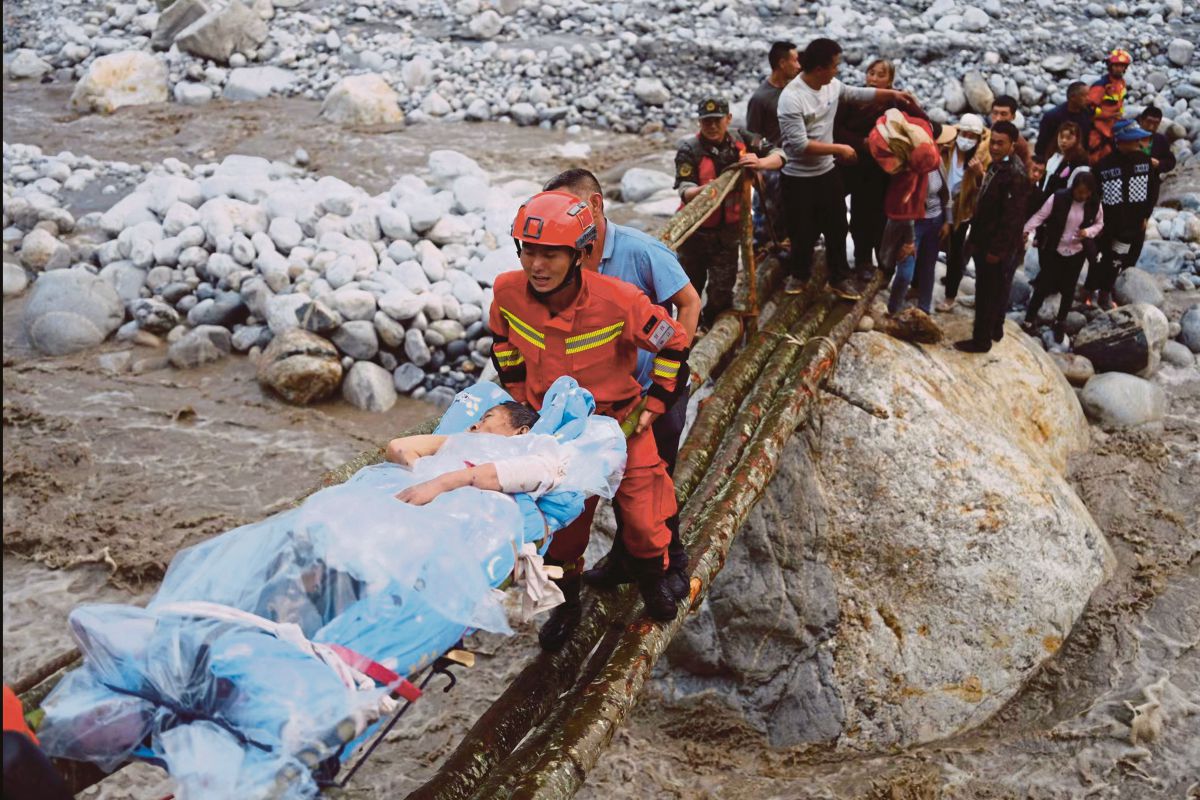 PASUKAN penyelamat mengusung mangsa gempa bumi di bandar Moxi di Luding, Sichuan. FOTO AP 