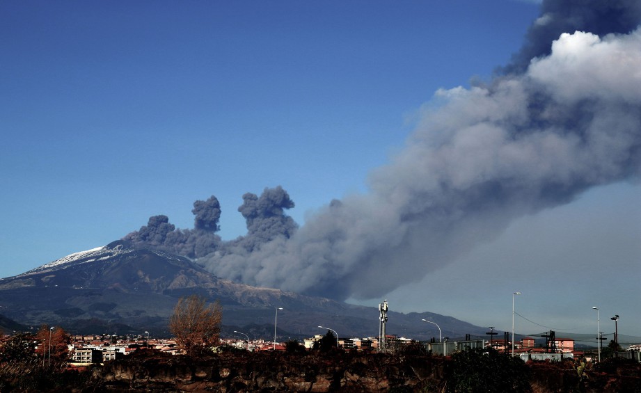 Asap menjulang di bandar Catania ketika letusan Gunung Etna, gunung berapi paling aktif di Eropah semalam. -Foto AFP