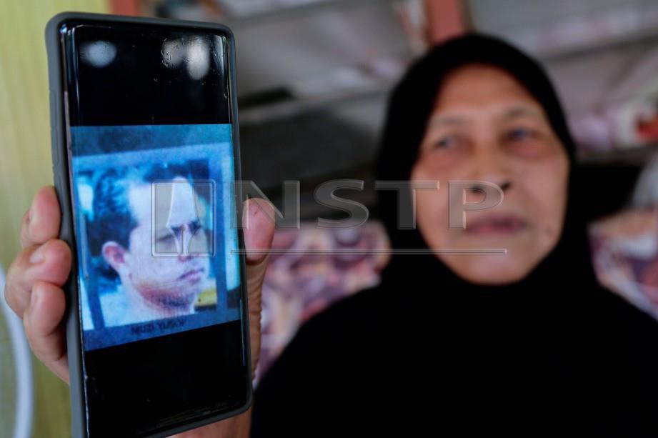 SAEMAH menunjukkan wajah Muzi Yusop yang merupakan antara sebahagian mangsa tragedi MH370. FOTO/AIZUDDIN SAAD