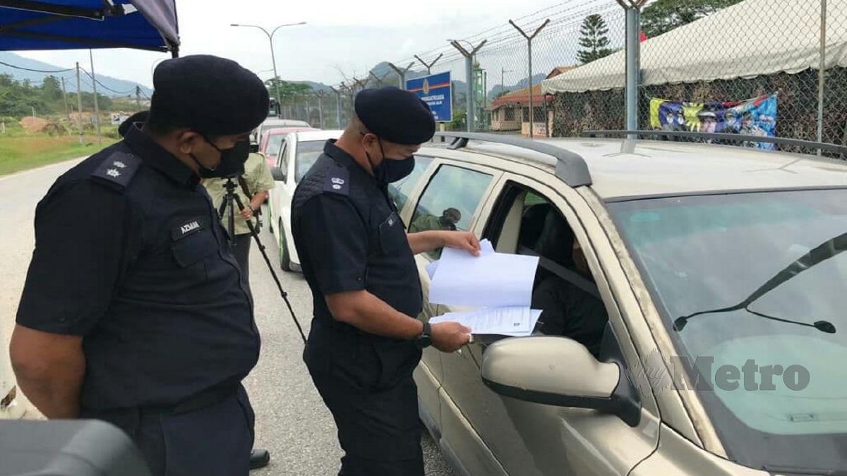 SIK (kanan) memperketatkan pemeriksaan ke atas kenderaan rentas negeri di SJR Jalan Gua Musang-Kuala Lipis. FOTO RAMLI IBRAHIM
