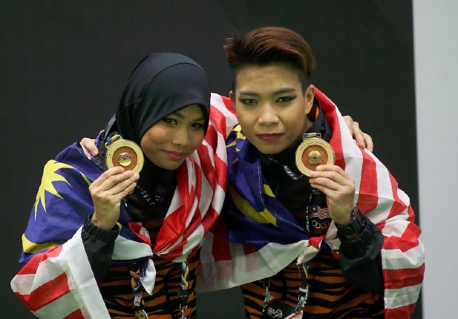 HAMIZAH (kiri) dan Syazreen memenangi pingat emas acara pencak silat kategori seni ganda akhir Wanita . 
