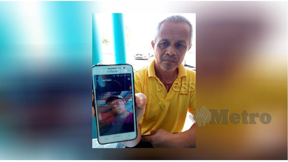 SULAIMAN Mohamad menunjukkan telefon bimbit mengandungi gambar arwah Mohd Sukhairi ketika ditemui di rumahnya di FELDA Kemelah, Segamat. FOTO Ahmad Ismail.