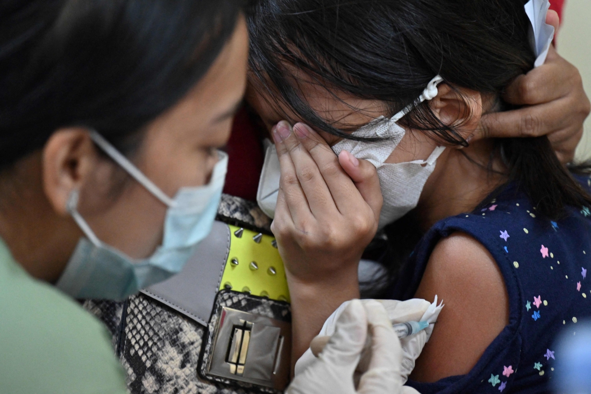 KANAK-KANAK menerima vaksin Covid-19 Sinovac di sebuah sekolah di Jakarta. FOTO AFP 