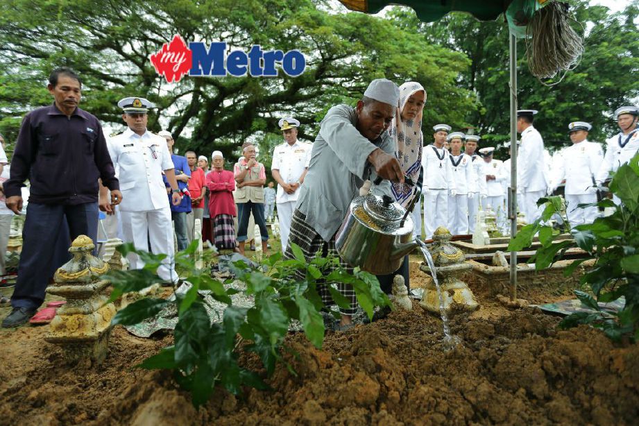 Mohd Sukri Salleh, 52, menyiram air ke pusara anaknya, Muhammad Laillatulman di Tanah Perkuburan Islam Rantau Panjang. FOTO Fathil Asri