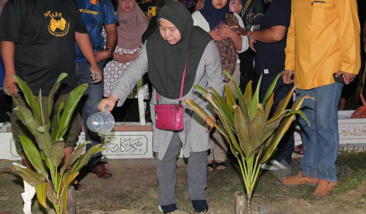 AZMAWATI menyiram air selepas selesai pengembvmian anaknya Muhammad Iman Aqmar di Tanah Perkvburan Islam Pasir Putih, Pasir Gudang. FOTO Nur Aisyah Mazalan