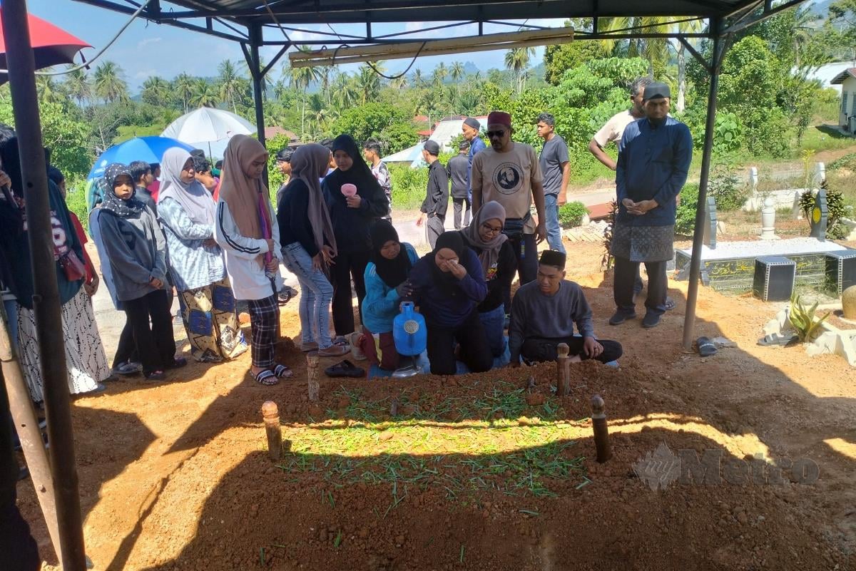 Norzalifa menyiram air di atas kubur dua anaknya, Ahmad Zuhal dan Ahmad Marikh yang meninggal dunia dalam nahas di KM 38, Jalan Ipoh-Kuala Kangsar, di sini pagi tadi. MUHAMMAD ZULSYAMINI SUFIAN SURI