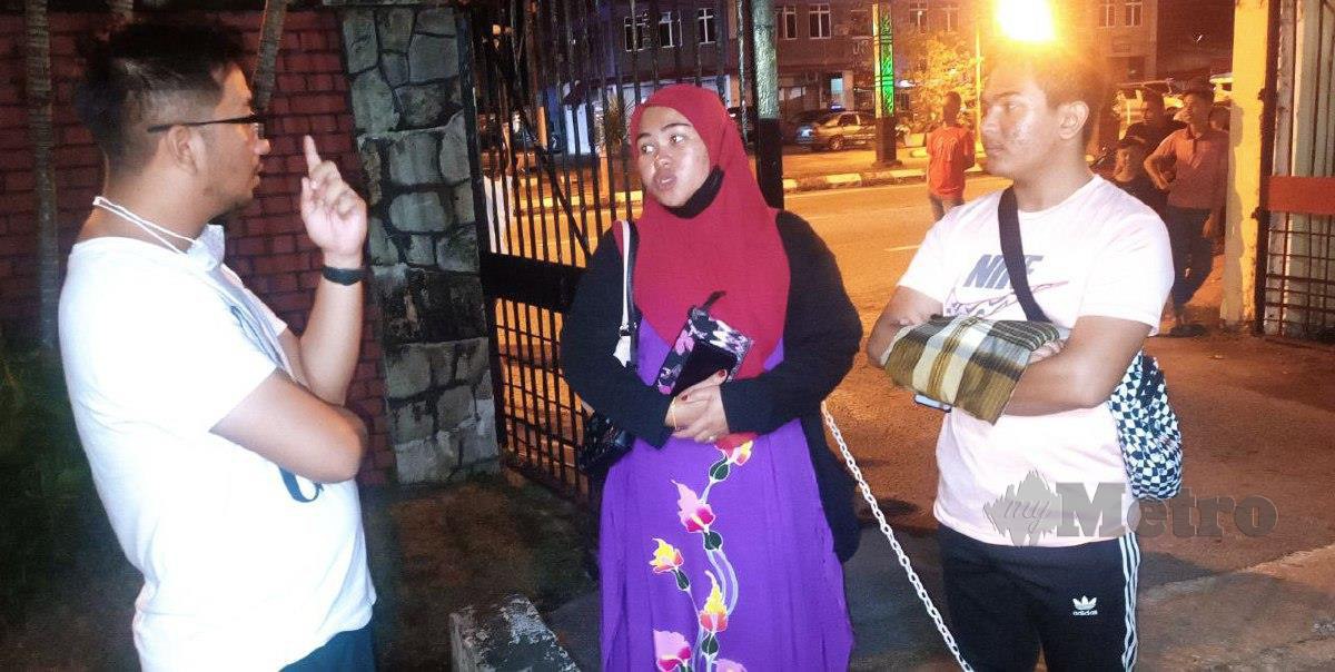 Siti Hajar (tengah) ketika menunggu proses bedah siasat mayat anak saudaranya, Muhammad Faris Haiqal Mohd Faizal di Bilik Forensik Hospital Dungun. FOTO ROSLI ILHAM