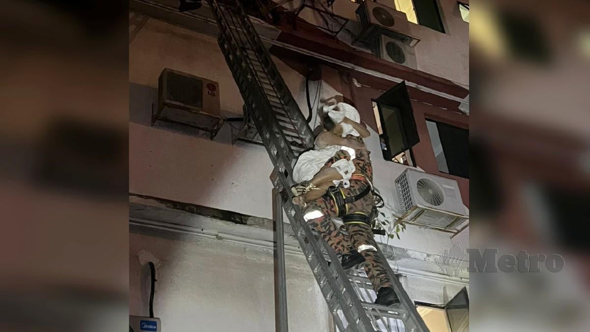 ANGGOTA bomba menyelamatkan seorang wanita dipercayai kurang siuman yang cuba terjun dari bangunan hotel. FOTO ihsan Bomba Selangor