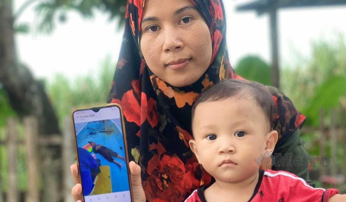 WAN Zainab menunjukkan gambar abang iparnya, Mohammad Ismail yang ditemui selamat. FOTO Rosli Ilham