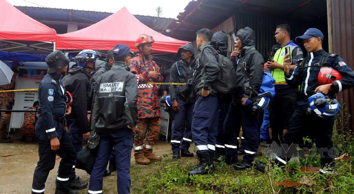 PASUKAN Smart mendengar taklimat daripada pegawai bomba berkaitan kejadian tanah runtuh di Kampung Batu 59, Kg. Raja yang membabitkan lima mangsa. FOTO L Manimaran