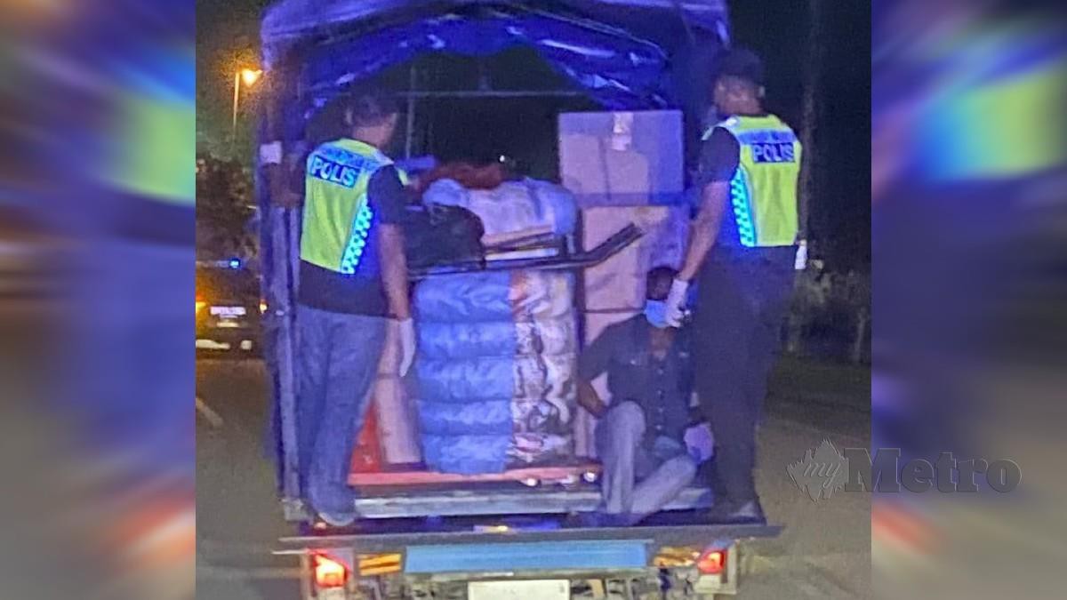 POLIS menahan lelaki warga India bersembunyi di belakang lori di sekatan jalan raya di sempadan Pahang -Terengganu dekat Chendor. FOTO ihsan polis