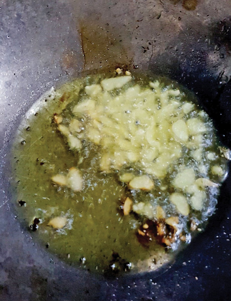 1. PANASKAN minyak dan goreng bawang putih hingga bertukar warna kekuningan. 