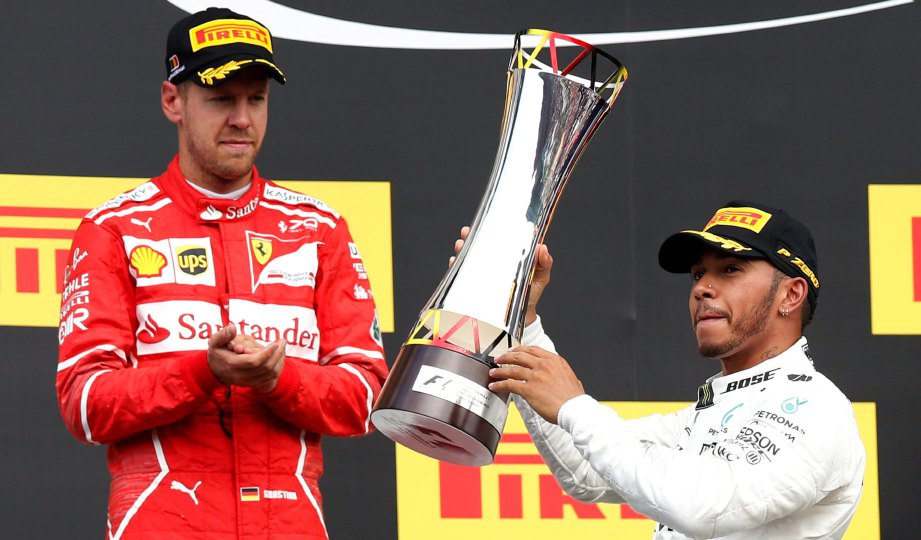 HAMILTON (kanan) meraikan kejuaraan di GP Belgium sambil disaksikan Vettel. FOTO Reuters