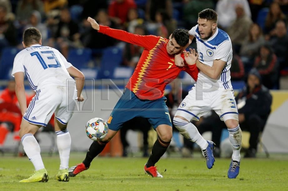 PEMAIN Sepanyol, Alvaro Morata (tengah) mengekang bola daripada pemain Bosnia Ermin Bicakcic dan Gojko Cimirot.   FOTO/REUTERS 