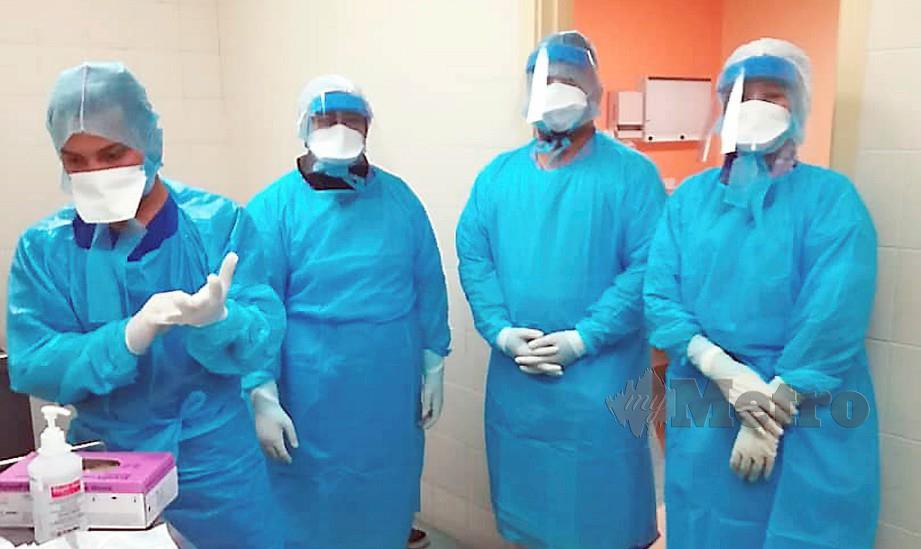 Petugas pengurusan jenazah JAWI lengkap berpakaian sut peralatan perlindungan diri (PPE) ketika menguruskan jenazah mangsa Covid-19.