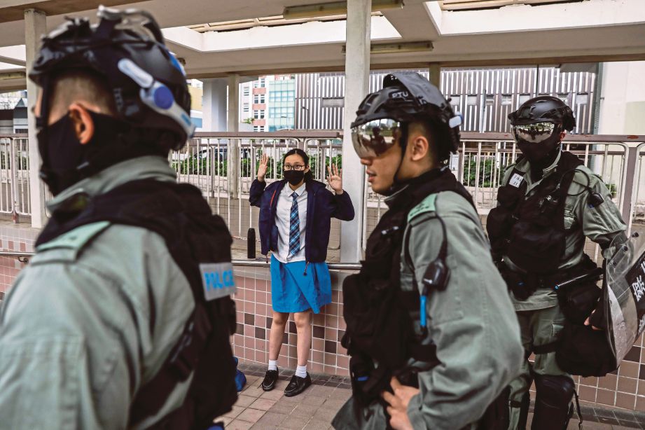 MURID sekolah disoal pihak polis di daerah Sai Wan Ho, Hong Kong berikutan protes pro-demokrasi yang diadakan semalam. FOTO AFP