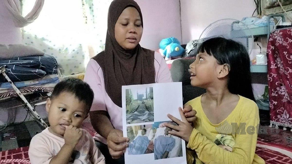 Siti Hamidah bersama dua orang anaknya sedang melihat gambar suaminya, Muhammad Hisham yang koma akibat jangkitan kuman di  bahagian paru-paru, jantung dan otak. FOTO Noorazura Abdul Rahman