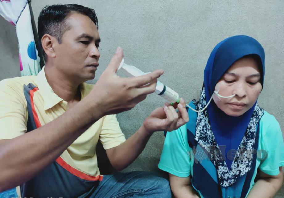 AZIZAN memberi isterinya, Sufiza susu melalui tiub selepas mengidap kanser esofagus tahap tiga sejak Mei tahun lalu. FOTO Noorazura Abdul Rahman